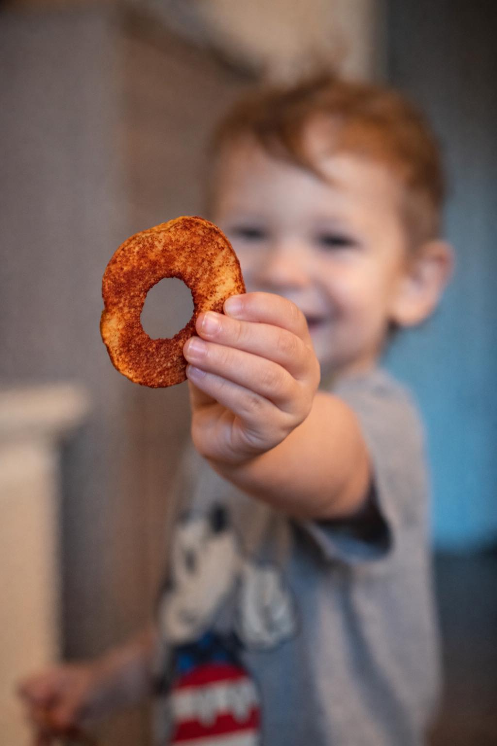 Child holding up an apple chip