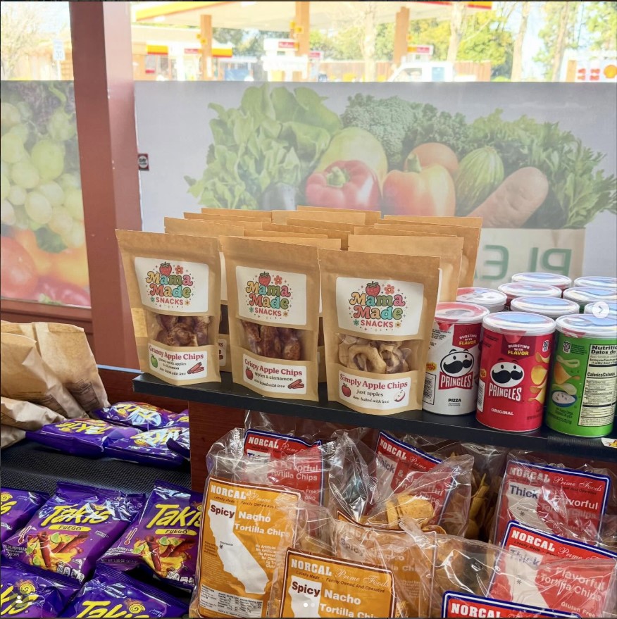 Mama Made Snacks bags displayed on a store shelf beside other snack brands